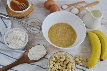 Ingredients for Banana Pancakes Preparation Baking Accessories Kitchen Composition Wooden Table Top Metal Whisk Wooden Spoon Banana Eggs Milk