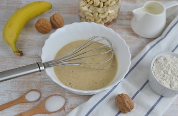 Ingredients for Banana Pancakes Preparation Baking Accessories Kitchen Composition Wooden Table Top Metal Whisk Wooden Spoon Banana Eggs Milk