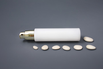 Cosmetics with a dispenser with stones on a gray background