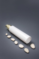 Cosmetics with a dispenser with stones on a gray background