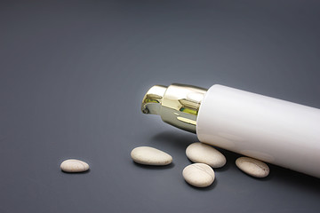 Cosmetics with a dispenser with stones on a gray background