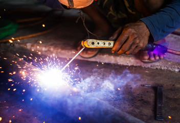 Hand of man welding steel blurred on black background