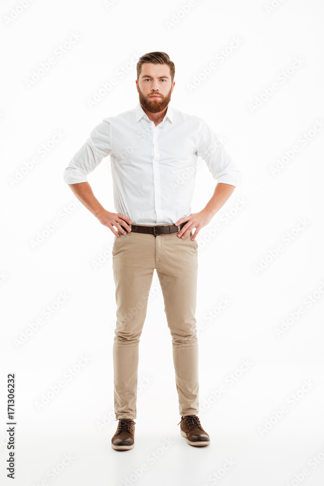 Canvas Prints Serious young bearded man standing over white wall