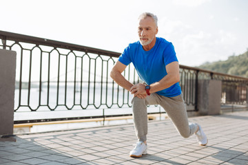 Senior man doing lunges during morning run