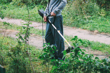 a man mowing the grass electric trimmer