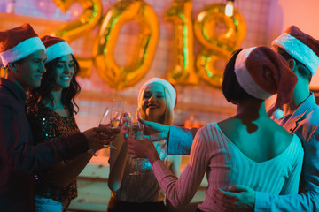 multiethnic friends clinking glasses of champagne