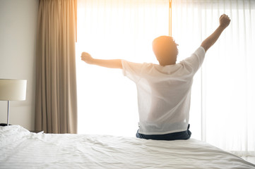 Man wake up and stretching in morning with sunlight - obrazy, fototapety, plakaty