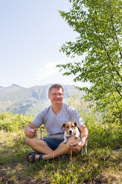 tourist with a dog rests in the mountains