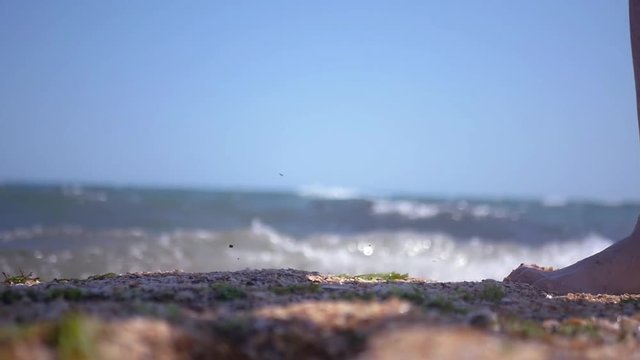 Bare feet of a man walking along the sandy beach of the sea, close-up. HD, 1920x1080. slow motion.