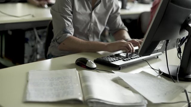 Lernen vor Computer mit B&uuml;cher und Arbeitsbl&auml;tter - Mann schreibt auf Tastatur