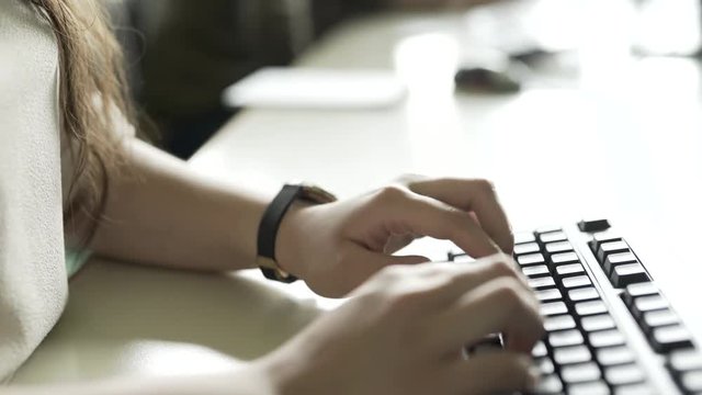 Frau schreibt auf Computer Tastatur