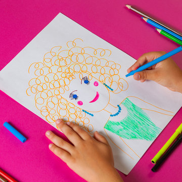Child draws picture of mom for mother's day. Little girl made a drawing with pencil and marker.