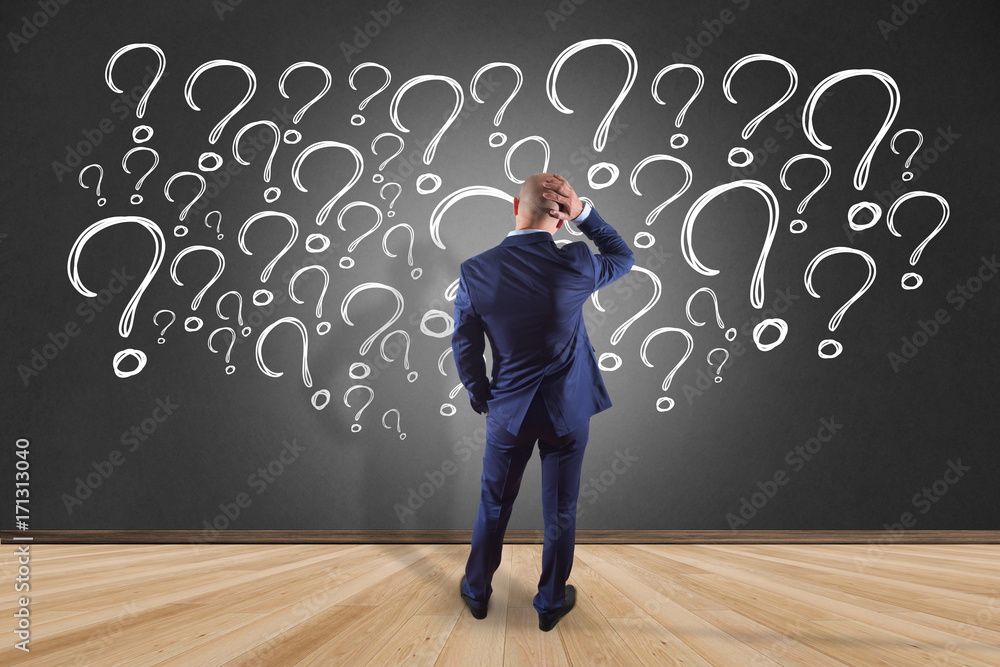 Poster view of a businessman in front of a wall trying to find find answers - daily life concept