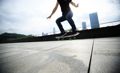 Woman skateboarder skateboarding at sunrise city