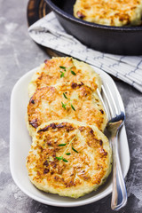 Zucchini fritters in cast iron skillet and ingredients. Selective focus, close up.