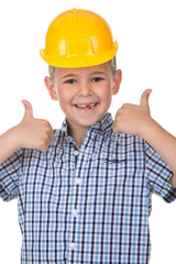 Smiling handsome caucasian teen boy in a yellow hard hat. Happy child making thumbs up gesture and looking at camera.