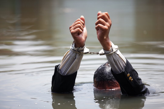 businessman was arrested by handcuffs and drowning in water with copyspace.