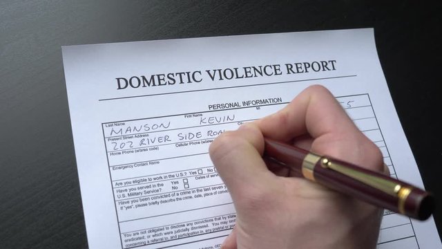 Filing a domestic violence report by hand. This form is randomly filled with no real names or numbers.