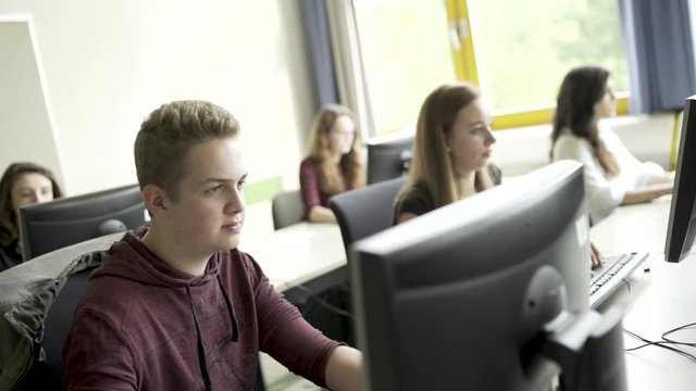 Junge und M&auml;dchen lernen gemeinsam im Klassenzimmer Computerraum