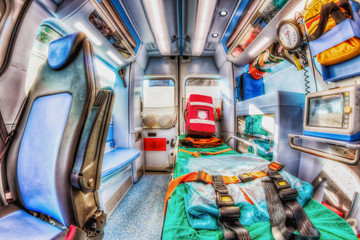 Inside the ambulance, view from the sanitary compartment. Different medical equipment and a stretcher. Selective focus, high key.