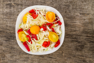 Fresh vegetable salad on rustic wooden table