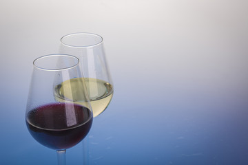 Glasses of wine on light blue background