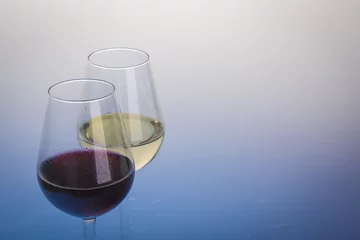 Fotobehang Glasses of wine on light blue background © AG Photo Design