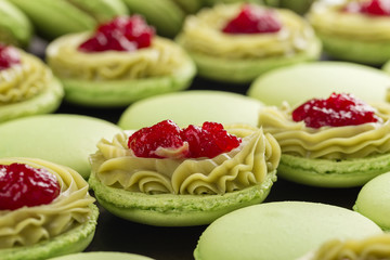 Green macaroons with pistachios ganache cream and raspberries confit filling