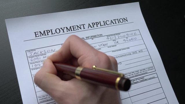 Filing an employment application form by hand. This form is randomly filled with no real names or numbers.