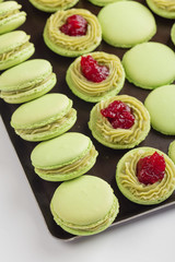 Green macaroons with pistachios ganache cream and raspberries confit filling