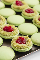 Green macaroons with pistachios ganache cream and raspberries confit filling