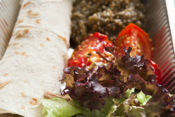 Healthy food in foil boxes, diet concept. Flatbread roll and tomatoes