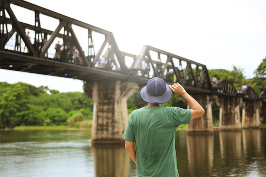 Man tourist is traveling at Kanchanaburi and watching history of World War 2, The bridge on the River Kwai.
