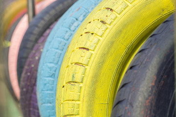 Colorful tires. Kindergarten, school field playground. Green artificial grass field ,reused rubber...