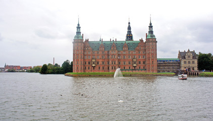 Obraz premium View of Frederiksborg castle (slot) from the garden, cloudy weather, Hillerod, Denmark