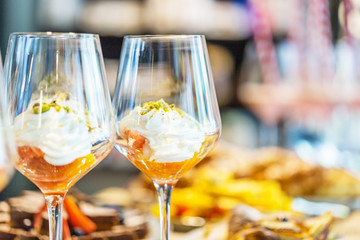 Dessert in Glass with Whipped Cream, Orange and Pistachio, Close-up View