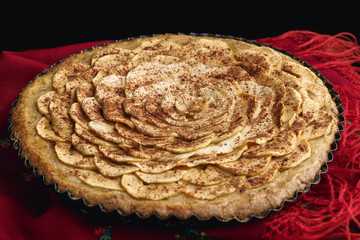 Apple tart lying on traditional Ukrainian headscarf