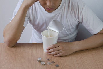 Freelance man not have salary look at the coins, stressed out in the end of mouth ,eat instant noodles.