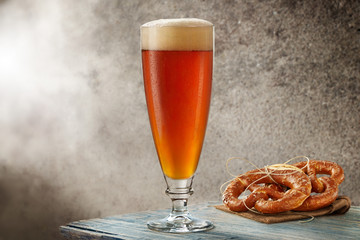 Bicchiere di birra con gocce e brezel