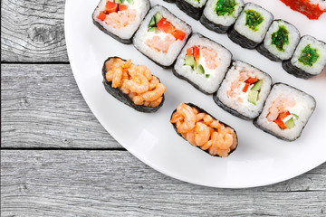 Colorful set of sushi and rolls top view on wood, closeup