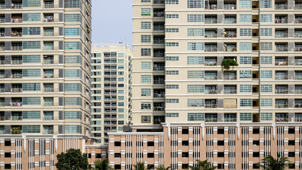 Straight facades of condominium buildings. Concept of dense population, overpopulation, living in modern style residence / high rise condominium.
