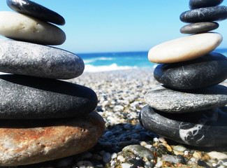 Pyramid of stones on the beach against the sea and sky