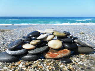 Pyramid of stones on the beach against the sea and sky