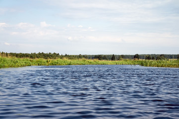 Blue ripples on the surface of the water against the blue sky.