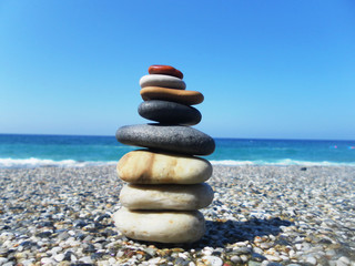 Pyramid of stones on the beach against the sea and sky