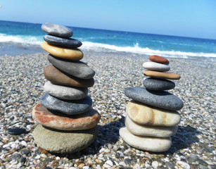 Fototapeta premium Pyramid of stones on the beach against the sea and sky