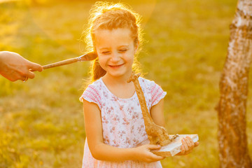 Mother's hand tickles the cheek with a brush to paint her little daughter, six-year old. Art,...