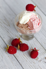 Ice cream and raspberries on a white rustic wooden table. Shallow depth of field
