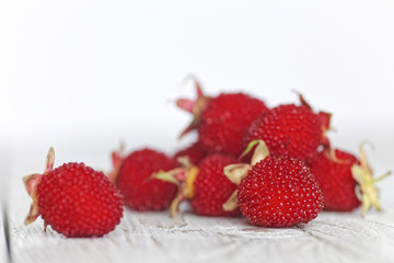 Tibetan raspberry on a rustic white wooden table. Red berries on white. Shallow depth of field