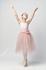 Fototapeta na wymiar the little ballerina is pulling her hands